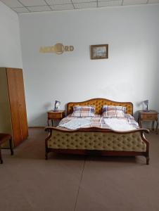 een groot bed in een kamer met 2 tafels bij Art House Hostel Aleksandr in Koetaisi