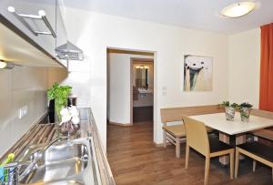 a kitchen and dining room with a sink and a table at Residence Mignon in Rifiano