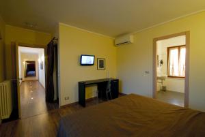 Cornaleto的住宿－Affittacamere Il Persicone，一间卧室配有一张床,墙上配有电视
