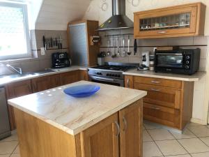 a kitchen with a blue bowl on a wooden island at Maison près de Bon repos in Laniscat +5 photos