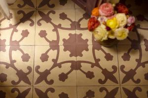 a vase of flowers sitting on a tiled floor at Gatto Perso Luxury Studio Apartments in Thessaloniki
