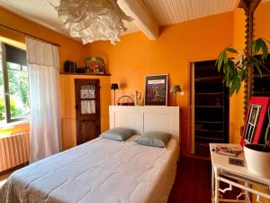 ein Schlafzimmer mit einem großen weißen Bett in einem Zimmer in der Unterkunft la maison d'Anna chambres d hôtes in Ganac