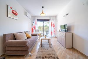 ein Wohnzimmer mit einem Sofa und einem TV in der Unterkunft Apartments Svetlana in Tivat