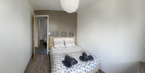 sypialnia z łóżkiem z czarnymi butami w obiekcie La petite Boutique Rouge w mieście Cayeux-sur-Mer