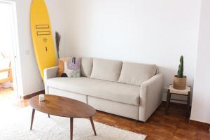 a living room with a couch and a surfboard on the wall at Casa da Raposa by MOJE Holiday in Lagos