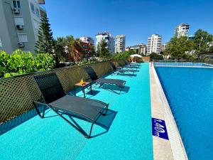 a row of chairs sitting next to a swimming pool at Zeynel Hotel in Antalya