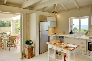 Il comprend une cuisine équipée d'un réfrigérateur et d'une table. dans l'établissement Kallista House, à Kourtaíïka 16 autres photos