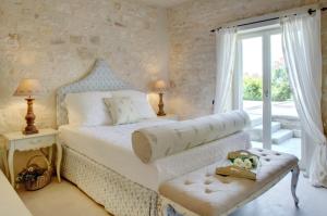 une chambre avec un lit blanc et une fenêtre dans l'établissement Kallista House, à Kourtaíïka