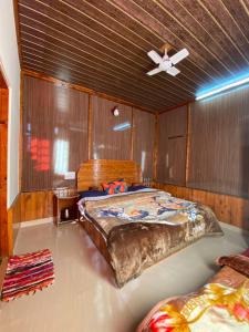 ein Schlafzimmer mit einem Bett und einem Deckenventilator in der Unterkunft SAIRRA - Hotel & Restaurant in Manali