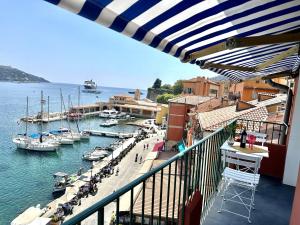 a balcony with a view of a marina with boats at MAISON BLEUE AP4362 By Riviera Holiday Homes in Villefranche-sur-Mer