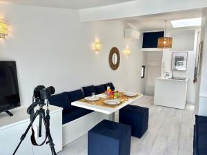 a camera on a tripod in a living room with a table at MAISON BLEUE AP4362 By Riviera Holiday Homes in Villefranche-sur-Mer