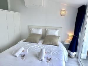 a white bed with two baby dolls on it at MAISON BLEUE AP4362 By Riviera Holiday Homes in Villefranche-sur-Mer
