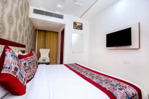 a bedroom with a bed with red pillows and a tv at Hotel Tamanna - 50 Meter from Golden Temple in Amritsar