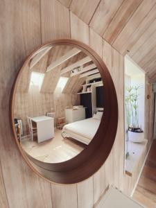 a circular mirror in a room with a bed and a table at La Bulle d'EMBRUNS d'HERBE in Plogoff