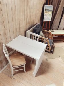 una mesa blanca y sillas en una habitación en La Bulle d'EMBRUNS d'HERBE en Plogoff