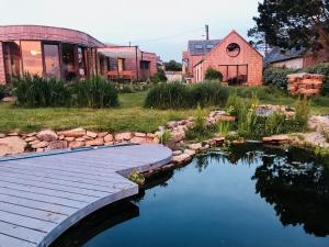 a wooden bridge over a pond in a yard at La Bulle d'EMBRUNS d'HERBE in Plogoff