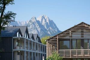 ein Haus und ein Gebäude mit einem Berg im Hintergrund in der Unterkunft quartier - über Nacht in besonderer Architektur in Garmisch-Partenkirchen