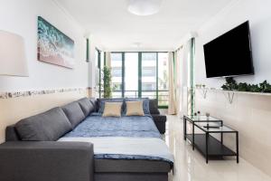 een woonkamer met een bank en een flatscreen-tv bij Tre spaziosi appartamenti a 150m dal lungomare di Las Americas in Arona