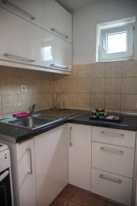 Una cocina con gabinetes blancos y un fregadero. en Apartment Una Mostar, en Mostar