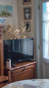 een flatscreen-tv op een ladekast bij chez margaut in Saint-Valery-sur-Somme