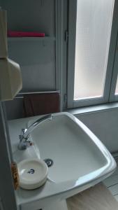 een witte wastafel in een badkamer met een raam bij chez margaut in Saint-Valery-sur-Somme +15 foto's
