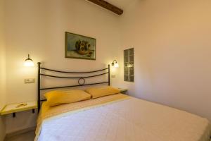 Apartments Casa Saina في روفينج: غرفة نوم عليها سرير ومخدات صفراء