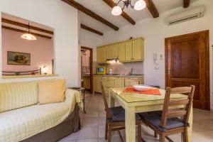Apartments Casa Saina في روفينج: مطبخ وغرفة معيشة مع طاولة وأريكة