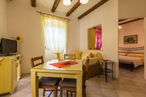 Apartments Casa Saina في روفينج: مطبخ وغرفة معيشة مع طاولة وتلفزيون