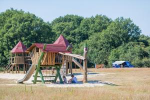 dwójka dzieci bawiących się na placu zabaw na polu w obiekcie Huttopia de Roos w mieście Stegeren