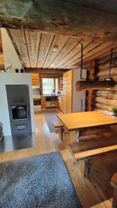 a living room with a wooden table and a stove at Kelokallas 2 Ruka in Ruka