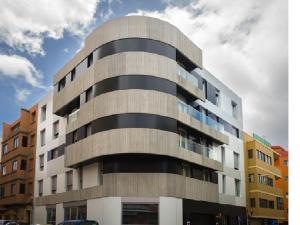 wysoki betonowy budynek z niebem w obiekcie Royal Suites w mieście Las Palmas de Gran Canaria