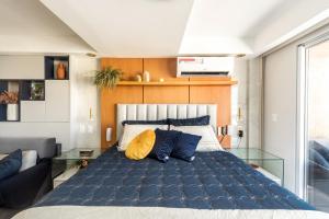 a bedroom with a large bed with blue and yellow pillows at DELUX PRAIA Flats in Natal