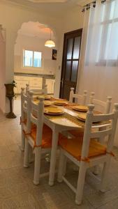 a dining room table with chairs and a white table and chairsktop at Mog'appart in Essaouira