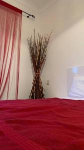 a bedroom with a red bed and a vase with a plant at Mog'appart in Essaouira