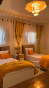 - une chambre avec 2 lits et un lustre dans l'établissement Mog'appart, à Essaouira