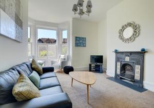 a living room with a couch and a fireplace at SandyCastle in Swanage