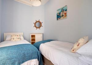 a bedroom with two beds and a mirror on the wall at SandyCastle in Swanage