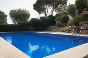 una gran piscina azul en un patio en Apartment Platja de Aro con piscina y vistas al mar, en Platja d'Aro