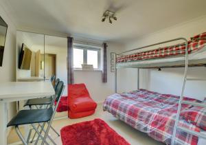 a bedroom with a bunk bed and a desk at 3 The Downs in Swanage