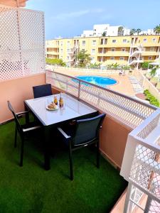 a table and chairs on a balcony with a pool at Cosy, new studio in Costa Adeje in Adeje