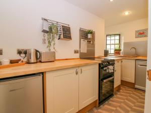 a kitchen with white cabinets and a counter top at The Wee Hideaway in Cupar