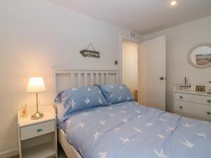 a bedroom with a bed with a blue comforter at The Wee Hideaway in Cupar
