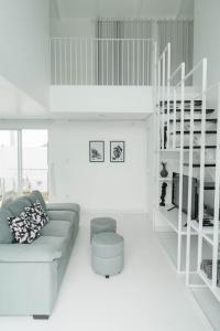 uma sala de estar branca com um sofá e uma prateleira em Villa IKIN em Ubud