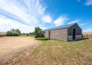 a stone building in a field with a sky at Wans Barton in Chickerell