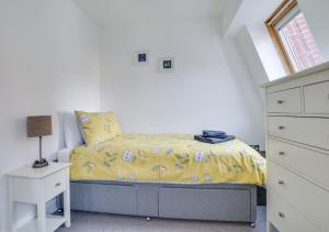 a bedroom with a bed with a yellow blanket at Marina View Townhouse in Weymouth