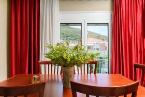 a dining room with a table and red curtains at Elia Villa Thassos in Prinos
