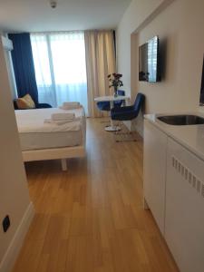 a bedroom with a bed and a kitchen with a sink at lux apartments orbi city in Angisa