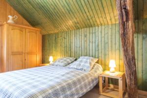 a bedroom with a bed and a wooden ceiling at Au Logis des Hirondelles 