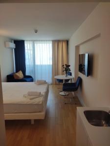 a bedroom with a bed and a sink in a room at lux apartments orbi city in Angisa