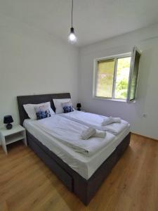 a bedroom with a large bed with white sheets and a window at Makach Apartments in Ohrid